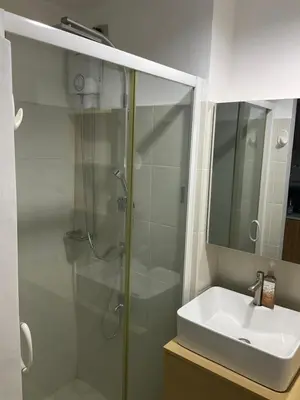 a bathroom with a shower and a sink at SEA Residences in Pasay near Mall of Asia in Manila