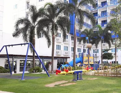 a playground in a park in front of a building at SEA Residences in Pasay near Mall of Asia in Manila