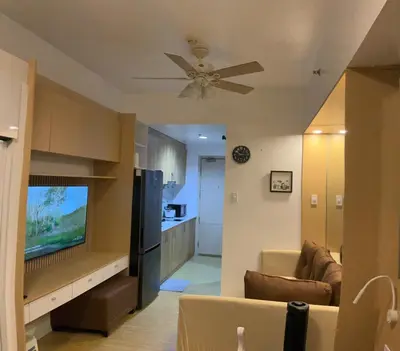a living room with a couch and a ceiling fan at SEA Residences in Pasay near Mall of Asia in Manila