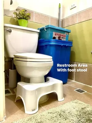 a bathroom with a toilet and a blue trash can at Borbon's Condo Suite in Manila