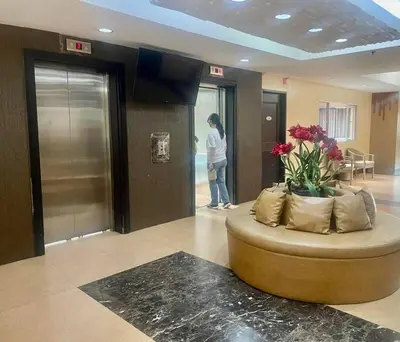a woman standing in a lobby with a round couch at Borbon's Condo Suite in Manila