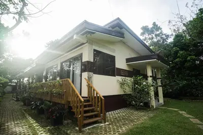 a house with a staircase in front of it at Tagaytay Foothills Cherimoya Farm Staycation in Biboyan