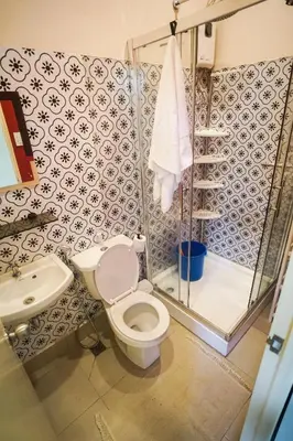 a bathroom with a toilet and a shower at Tagaytay Foothills Cherimoya Farm Staycation in Biboyan