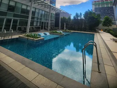 a large swimming pool in front of a building at 8U Pristine & Cozy Stay at Uptown Mall BGC across Mitsukoshi with FREE Parking and Balcony in Manila