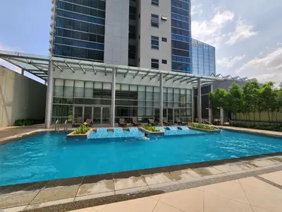 an overhead view of a swimming pool in front of a building at 8U Pristine & Cozy Stay at Uptown Mall BGC across Mitsukoshi with FREE Parking and Balcony in Manila