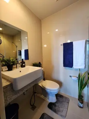 a bathroom with a white sink and a toilet at 8U Pristine & Cozy Stay at Uptown Mall BGC across Mitsukoshi with FREE Parking and Balcony in Manila