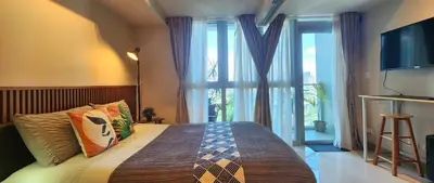 a bedroom with a bed and a large window at 8U Pristine & Cozy Stay at Uptown Mall BGC across Mitsukoshi with FREE Parking and Balcony in Manila