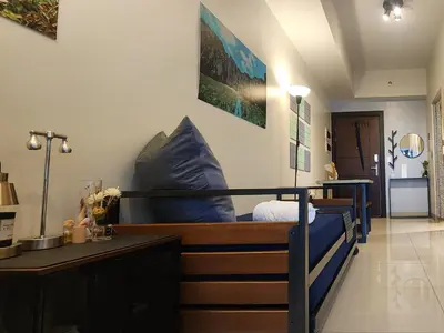 a bedroom with a bed with blue pillows on it at 8U Pristine & Cozy Stay at Uptown Mall BGC across Mitsukoshi with FREE Parking and Balcony in Manila