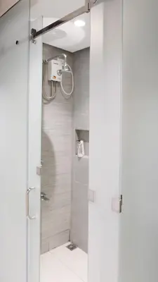 a shower with a glass door in a bathroom at The Grid Co-Living Managed by HII in Manila