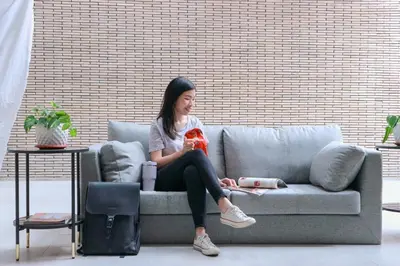 a woman sitting on a couch holding a teddy bear at The Grid Co-Living Managed by HII in Manila