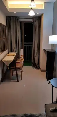 a living room with a chair and a table and a window at BayLIfe Escape in Manila