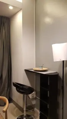 a table with a stool and a lamp in a room at BayLIfe Escape in Manila