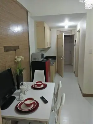 a white table with red plates on it in a kitchen at CHATEAU ELYSEE A11 Near Sm Mall and Airport in Manila
