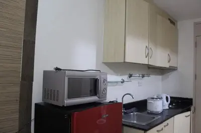 a kitchen with a microwave on top of a refrigerator at CHATEAU ELYSEE A13 Near Resto And Sm Mall/Airport in Manila