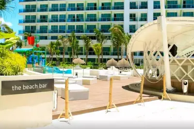 a hotel with a beach bar and a building at Azure Residence A8 Near Sm Mall/Airport +free wifi in Manila