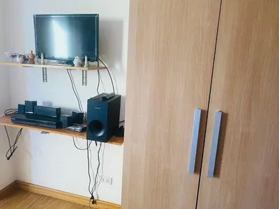 a wooden cabinet with a television on a shelf at Azure Residence A8 Near Sm Mall/Airport +free wifi in Manila