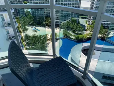 a balcony with a view of a pool and a resort at Azure Residence A8 Near Sm Mall/Airport +free wifi in Manila