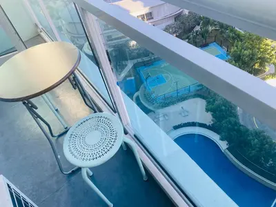 a balcony with a table and a swimming pool at Azure Residence A8 Near Sm Mall/Airport +free wifi in Manila