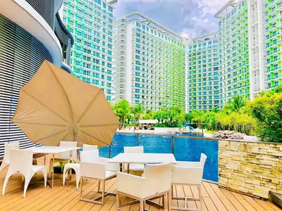 a patio with a table and chairs and a pool at Azure Urban Residence A10 Near Airport and SM Bicutan+ Free wifi in Manila