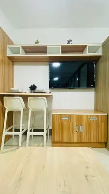 a kitchen with a counter and two stools in it at Cozy 1Br with Netflix & Balcony Pool View Condo in Manila