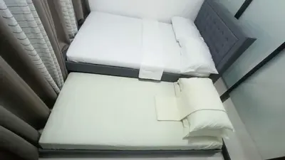 two beds in a room with white sheets and pillows at Cozy 1Br with Netflix & Balcony Pool View Condo in Manila