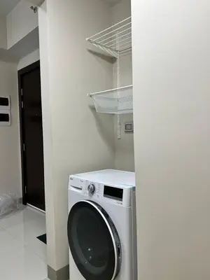 a washer and dryer in a room with a wall at Uptown Parksuites II in Manila