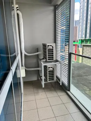 a balcony with a room with a heater and a window at Uptown Parksuites II in Manila