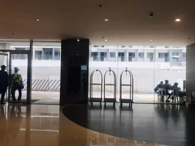 a lobby with people sitting at tables in a building at Shore Residence Staycation unit at Mall of Asia in Manila