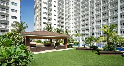 a garden with a gazebo in front of a large building at Shore Residences MOA Complex Staycation in Manila