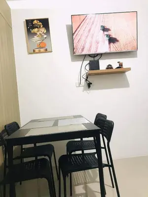 a black table with chairs and a tv on a wall at Condo- tel for At Mall of Asia Philippines in Manila
