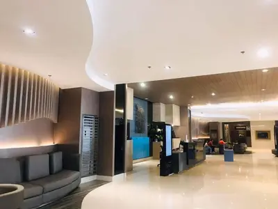 a lobby of a hotel with a couch and chairs at Condo- tel for At Mall of Asia Philippines in Manila