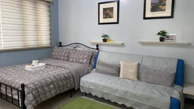 a bed and a couch in a room at Morgan Suite BGC shortwalk1 Venice Mall free pool in Manila