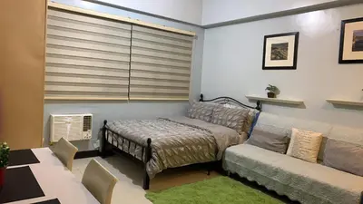 a living room with a couch and a bed and a window at Morgan Suite BGC shortwalk1 Venice Mall free pool in Manila