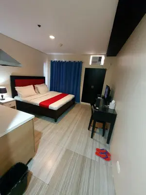 a bedroom with a bed and a desk with a computer at Sab R. Bel air soho in Manila