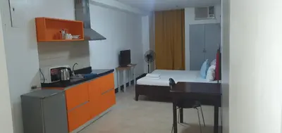 a kitchen with a bed and a desk in a room at Sab R. Bel air soho in Manila