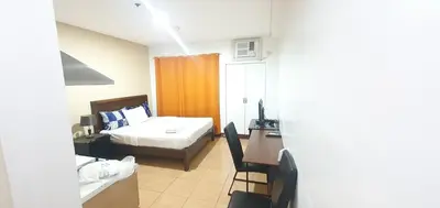a small room with a bed and a desk and a desk at Sab R. Bel air soho in Manila