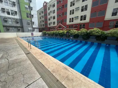 a swimming pool in the middle of some buildings at The Cozy Place Condo in Pasig Phil in Manila