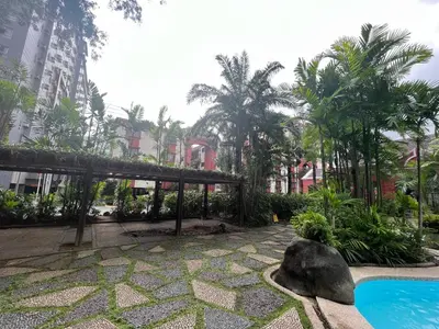 a resort with a swimming pool and trees and buildings at The Cozy Place Condo in Pasig Phil in Manila