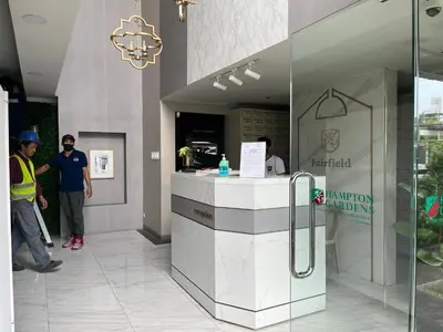 two men standing at a counter in a building at The Cozy Place Condo in Pasig Phil in Manila