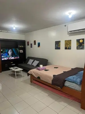 a bedroom with a bed and a couch and a flat screen tv at San Jose Residencias / enchanted kingdom / nuvali / slex / sta. rosa / paseo in Santa Rosa