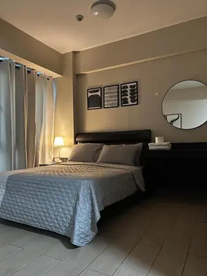 a bedroom with a bed and a large mirror at Cozy condo near Airport Manila in Manila