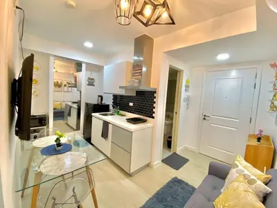 a kitchen and living room with a couch and a table at The Cozy-Corner Staycation at the Azure Urban Resort Residences in Manila