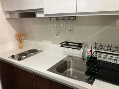 a kitchen counter with a sink and a stove at Makati amazing view Penthouse studio, Air Residence, fast internet in Manila