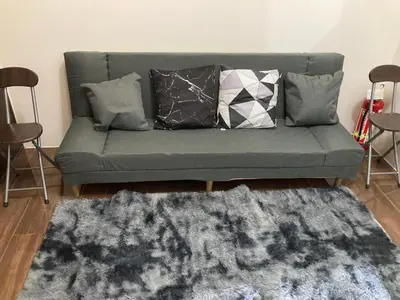 a living room with a couch with pillows and a rug at Makati amazing view Penthouse studio, Air Residence, fast internet in Manila