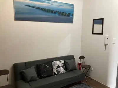 a living room with a couch and a painting on the wall at Makati amazing view Penthouse studio, Air Residence, fast internet in Manila