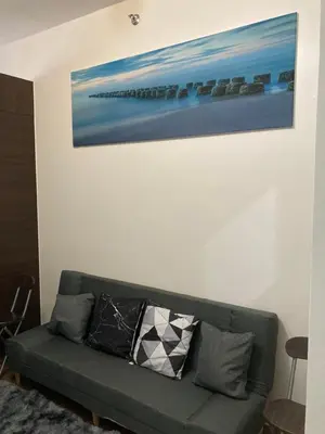 a couch in a living room with a painting on the wall at Makati amazing view Penthouse studio, Air Residence, fast internet in Manila