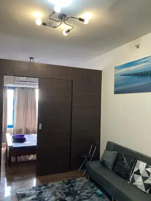 a living room with a couch and a sliding door at Makati amazing view Penthouse studio, Air Residence, fast internet in Manila