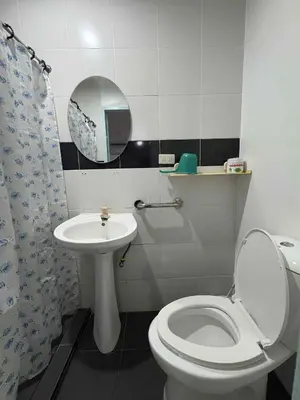 a bathroom with a toilet and a sink and a mirror at duck inn manila in Manila
