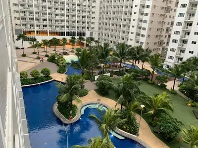 an aerial view of a resort with a pool and palm trees at 1 Bedroom lovely place near Mall of Asia in Manila