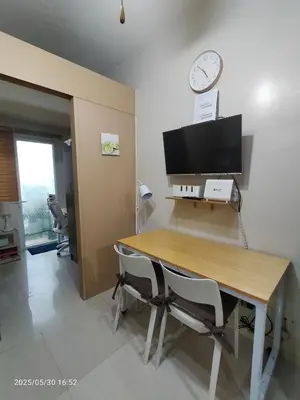 a dining room with a table and a clock on the wall at 821 Field Res Condo by Bambie with 2 wifi in Manila